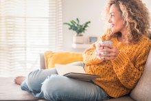 woman sits with coffee and journal