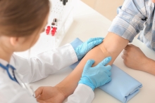 doctor prepping blood draw on patient arm