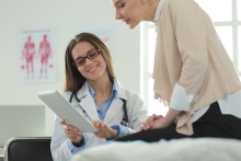 doctor reviews notes with female patient