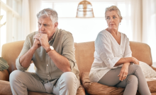 Image features a older couple sitting on a couch