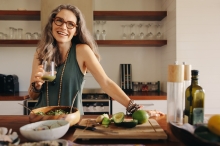 Woman making salad and drinking a healthy smoothie